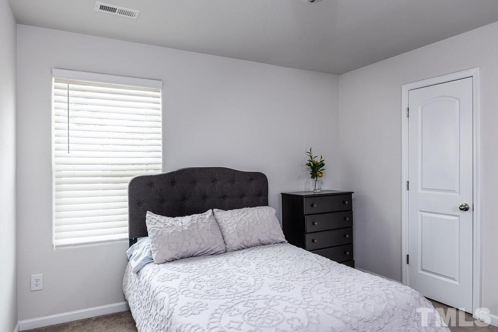 201 Rustling Way Zebulon, NC 27597 - Photo 21 of 30 a large bed sitting in a bedroom next to a window and dresser