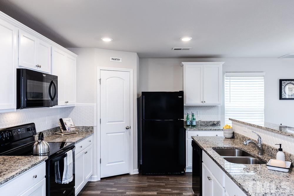 201 Rustling Way Zebulon, NC 27597 - Photo 7 of 30 a kitchen with a refrigerator stove and sink