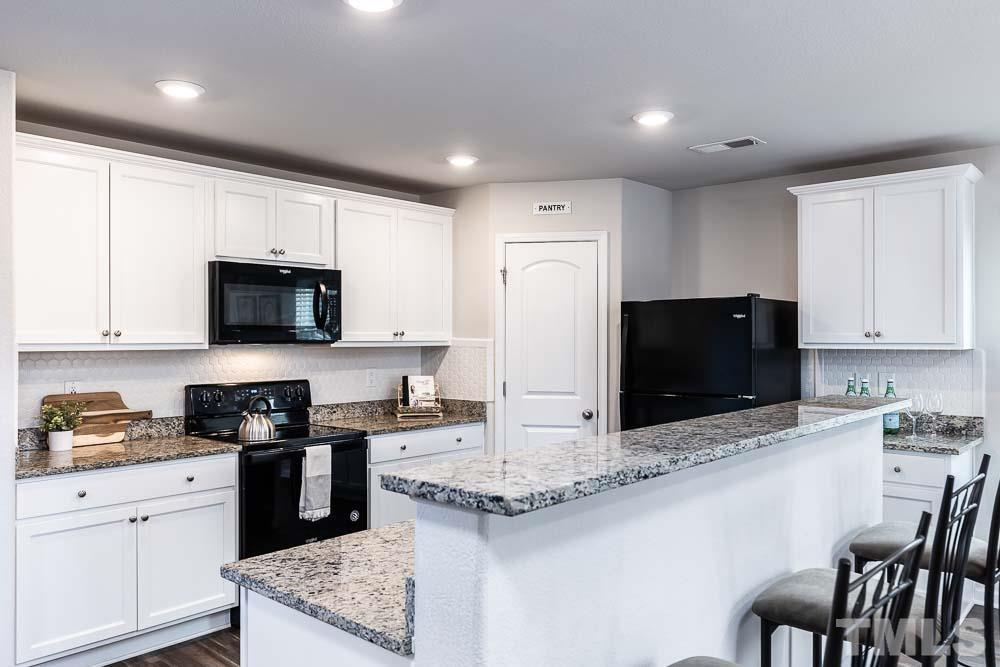 201 Rustling Way Zebulon, NC 27597 - Photo 9 of 30 a kitchen with stainless steel appliances granite countertop a stove a sink and a microwave