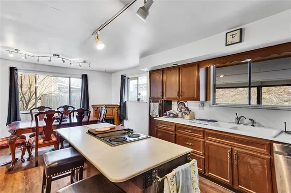 a kitchen with stainless steel appliances a stove a sink dishwasher and cabinets with wooden floor
