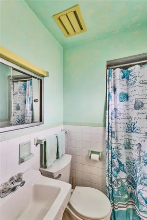 a bathroom with a toilet a sink and mirror