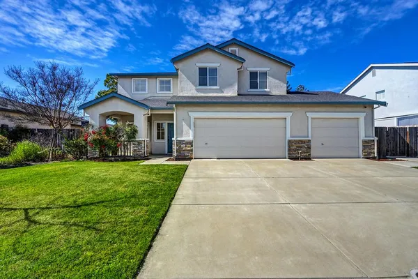 a front view of a house with a yard and garage