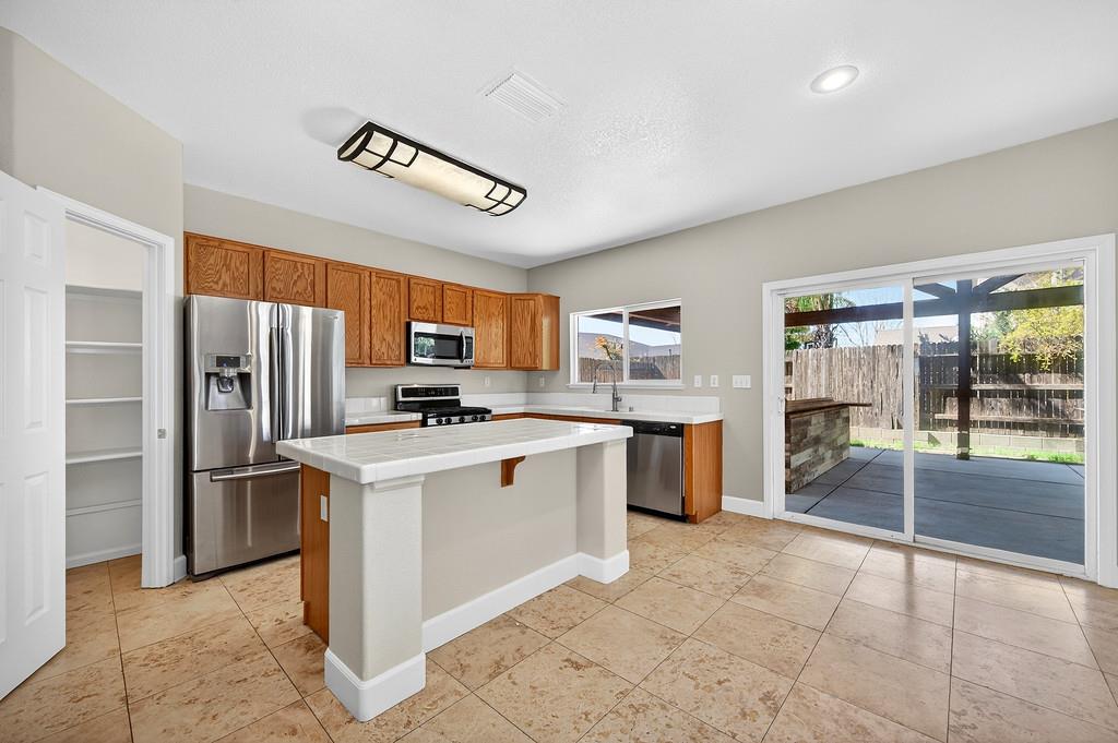 1619 7th Street Hughson, CA 95326 - Photo 12 of 61 a kitchen with stainless steel appliances a refrigerator and a stove top oven