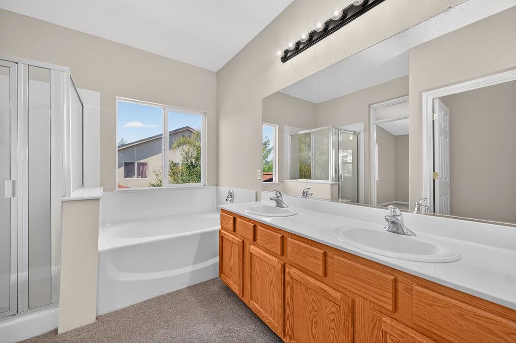 1619 7th Street Hughson, CA 95326 - Photo 29 of 61 a bathroom with a double vanity sink a mirror and a bathtub