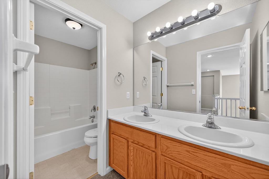 1619 7th Street Hughson, CA 95326 - Photo 38 of 61 a bathroom with a double vanity sink a toilet a mirror and bathtub