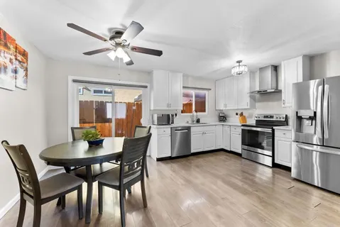 a kitchen with a dining table chairs appliances and cabinets