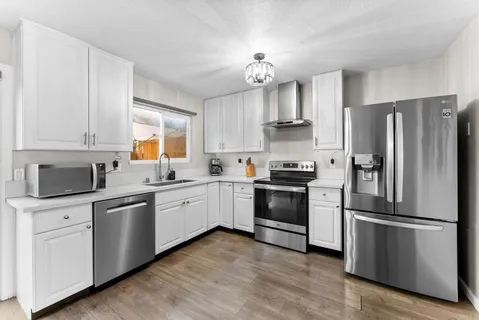 a kitchen with cabinets stainless steel appliances and a window