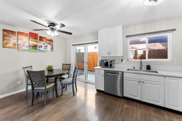 a kitchen with a dining table chairs and white cabinets