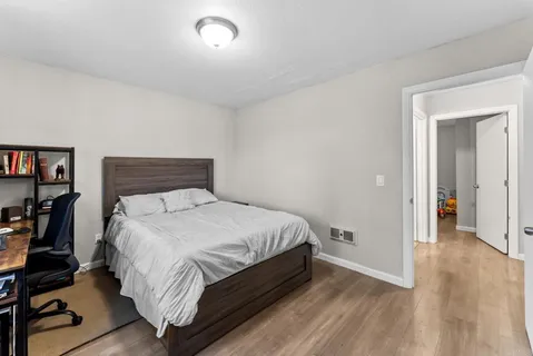 a bedroom with a bed and wooden floor