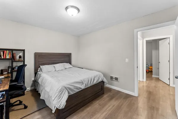 a bedroom with a bed and wooden floor