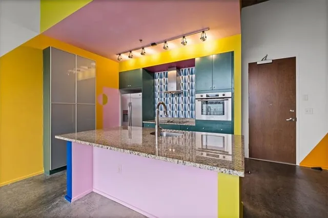 a kitchen with stainless steel appliances granite countertop a sink and a refrigerator