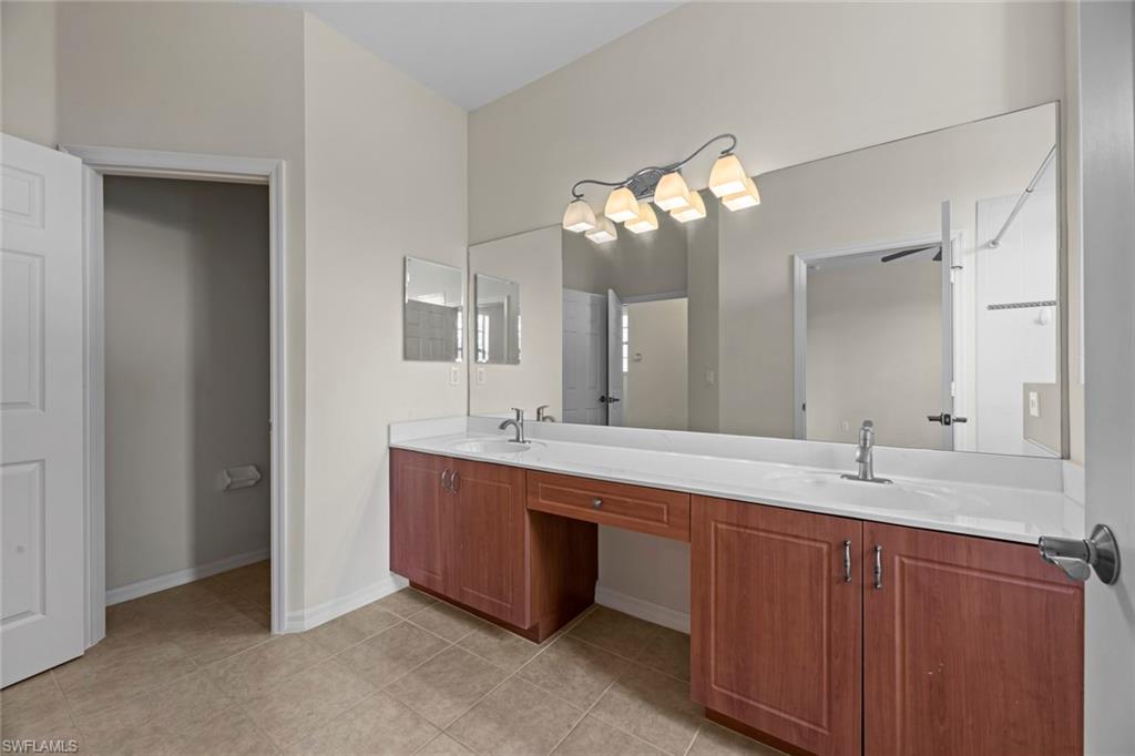15594 Summit Pl Circle, Unit 402 Naples, FL 34119 - Photo 12 of 45 a bathroom with a double vanity sink and a mirror