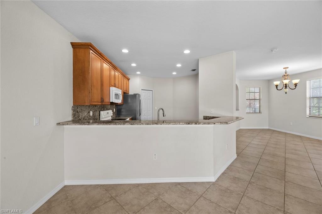 15594 Summit Pl Circle, Unit 402 Naples, FL 34119 - Photo 17 of 45 a view of kitchen with granite countertop lots of counter top space
