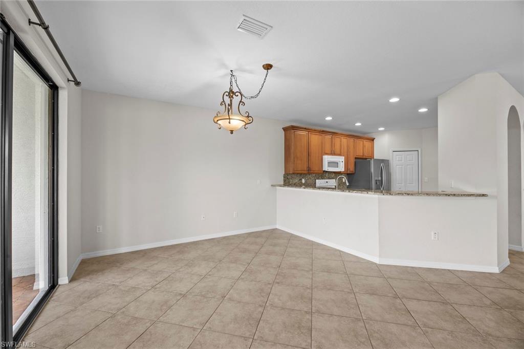 15594 Summit Pl Circle, Unit 402 Naples, FL 34119 - Photo 18 of 45 a view of kitchen with granite countertop cabinets and refrigerator