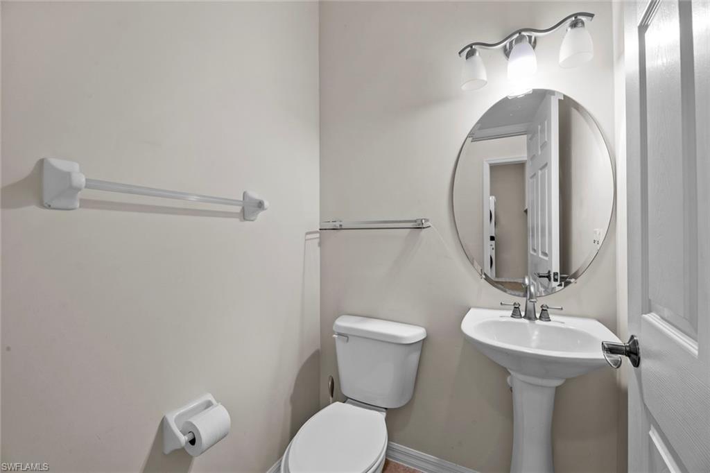 15594 Summit Pl Circle, Unit 402 Naples, FL 34119 - Photo 22 of 45 a bathroom with a toilet a sink and mirror