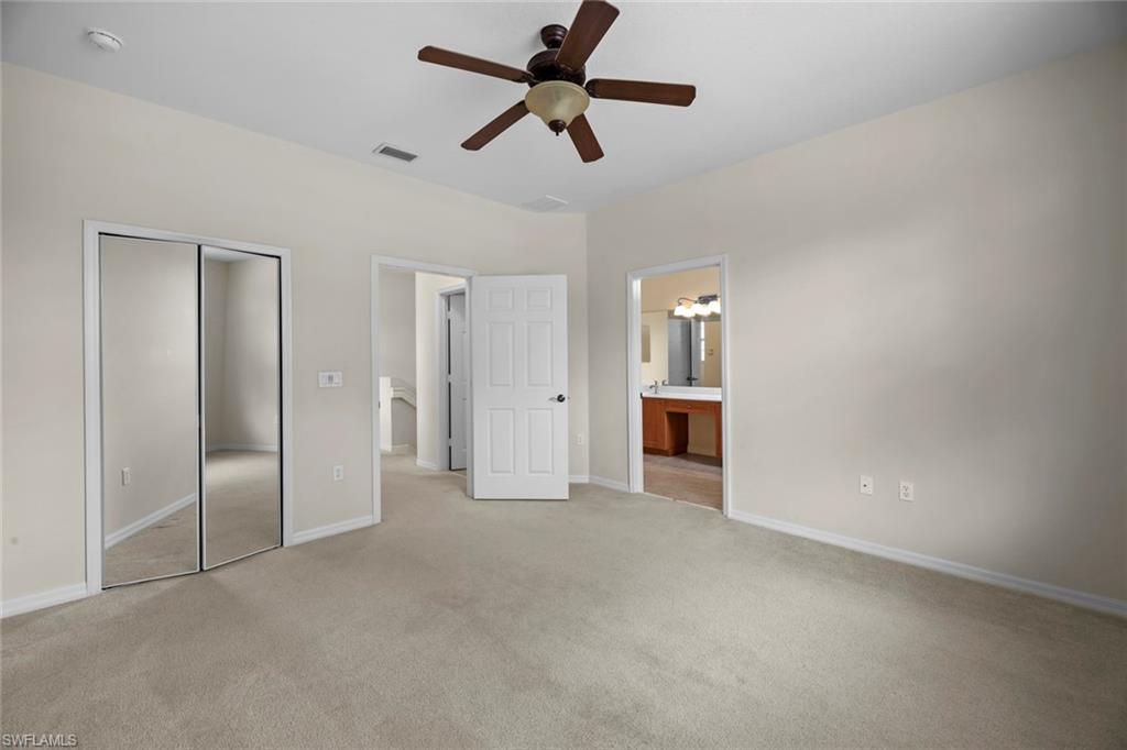 15594 Summit Pl Circle, Unit 402 Naples, FL 34119 - Photo 26 of 45 an empty room with chandelier fan and windows