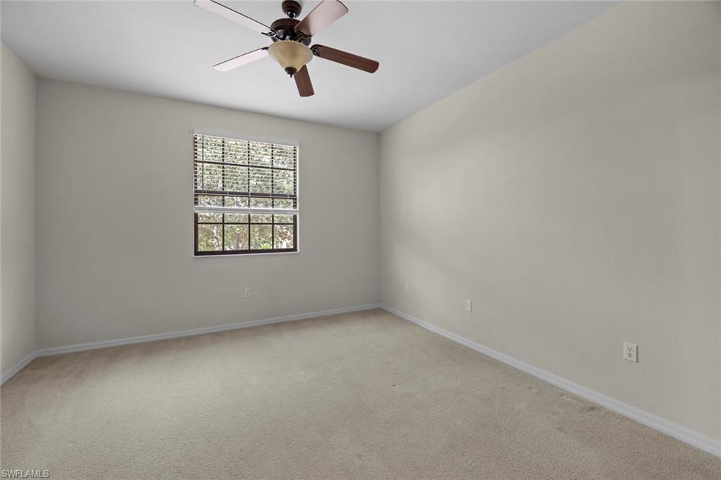 15594 Summit Pl Circle, Unit 402 Naples, FL 34119 - Photo 27 of 45 an empty room with a window and a fan