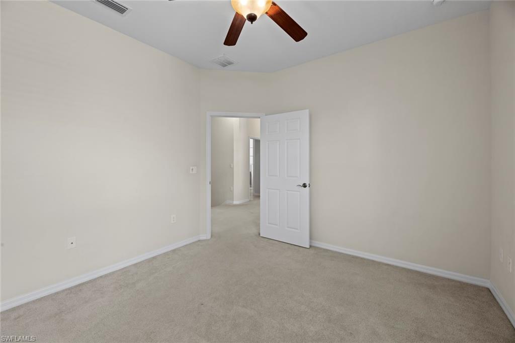 15594 Summit Pl Circle, Unit 402 Naples, FL 34119 - Photo 28 of 45 an empty room with a ceiling fan and hardwood floor