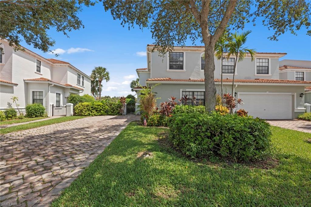 15594 Summit Pl Circle, Unit 402 Naples, FL 34119 - Photo 31 of 45 a view of a house with a small yard and a large tree