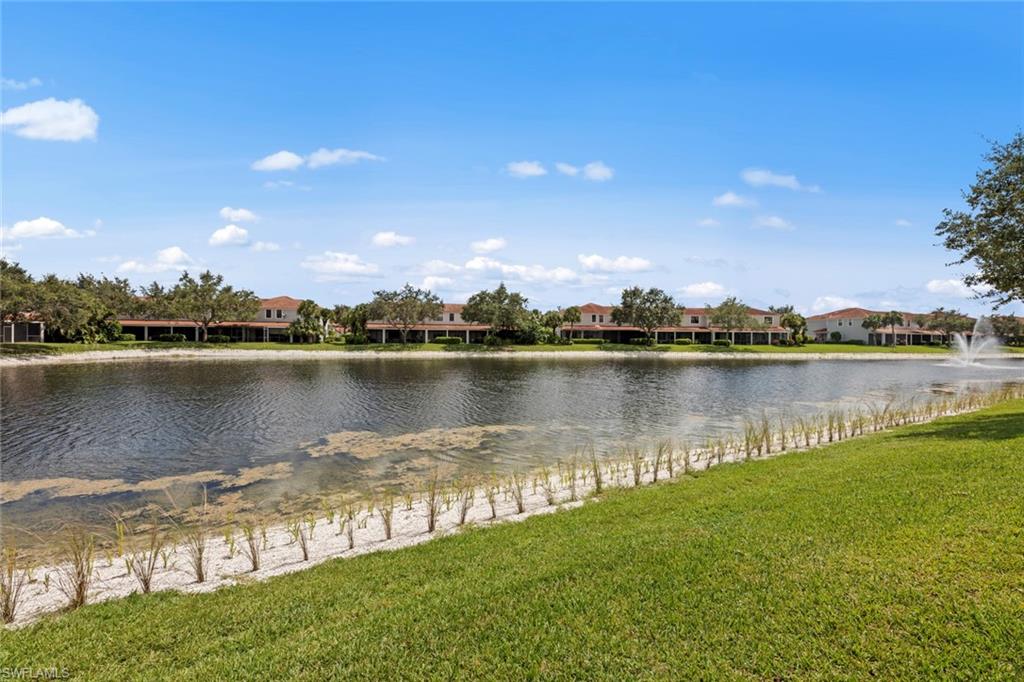 15594 Summit Pl Circle, Unit 402 Naples, FL 34119 - Photo 32 of 45 a view of a lake with houses in the background
