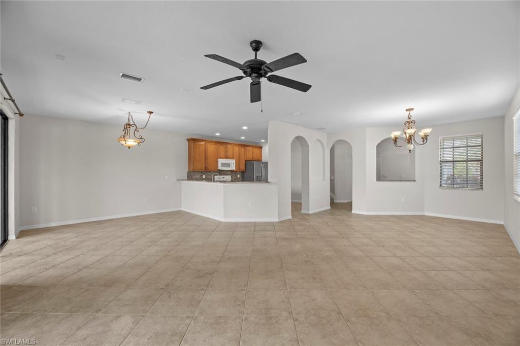 15594 Summit Pl Circle, Unit 402 Naples, FL 34119 - Photo 4 of 45 an empty room with windows and ceiling fan