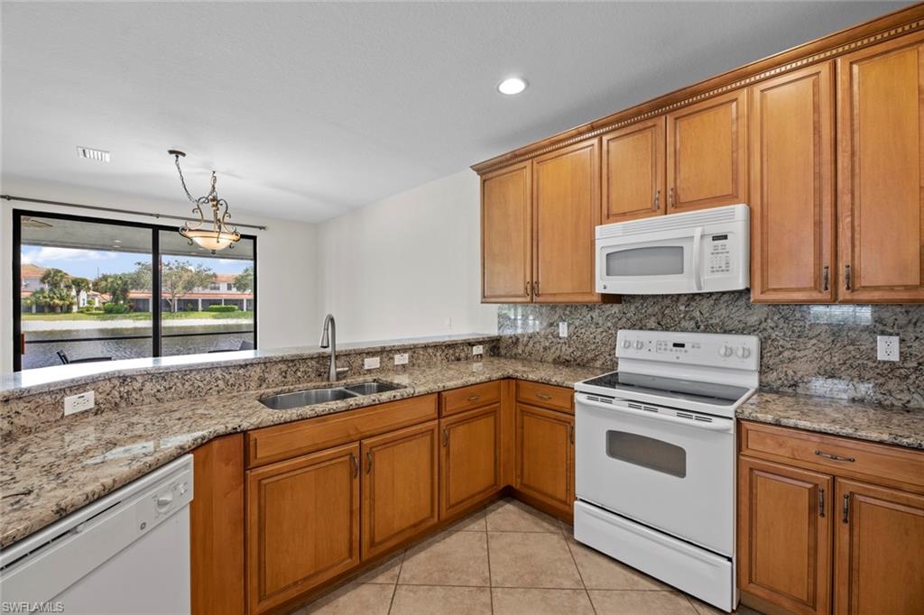 15594 Summit Pl Circle, Unit 402 Naples, FL 34119 - Photo 7 of 45 a kitchen with stainless steel appliances granite countertop cabinets and window