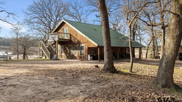 a view of a house with a yard and large tree