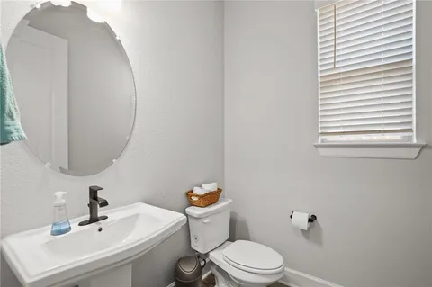 a bathroom with a sink a toilet and a mirror