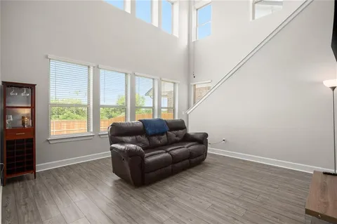 a kitchen with stainless steel appliances kitchen island granite countertop a refrigerator a stove top oven a sink dishwasher and a dining table with wooden floor