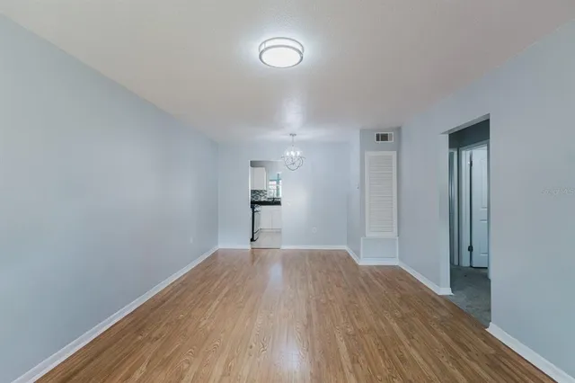 a view of empty room with wooden floor