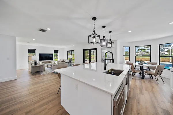 a very nice looking kitchen with granite countertop a stove and a wooden floors