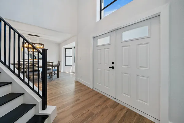 a view of a hallway with wooden floor and staircase