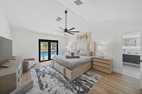 a bedroom with a large bed and a chandelier