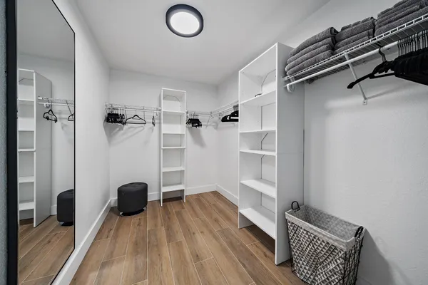 a view of walk in closet with clothes and shoes