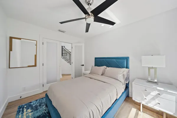 a bedroom with a bed and a lamp on a dresser