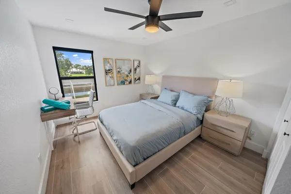 a bedroom with a bed painting on wall and a potted plant