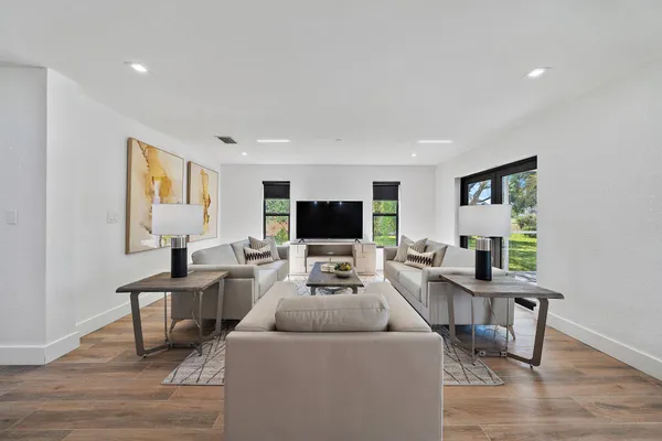 a living room with furniture a flat screen tv and a table