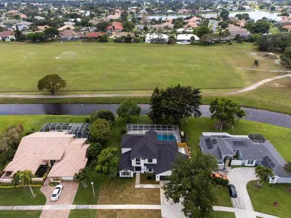 an aerial view of residential houses with outdoor space and lake view
