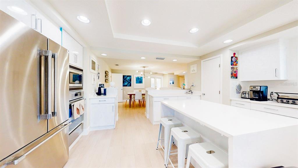 509 55th Avenue St. Pete Beach, FL 33706 - Photo 21 of 63 a large white kitchen with lots of counter space a refrigerator and a stove