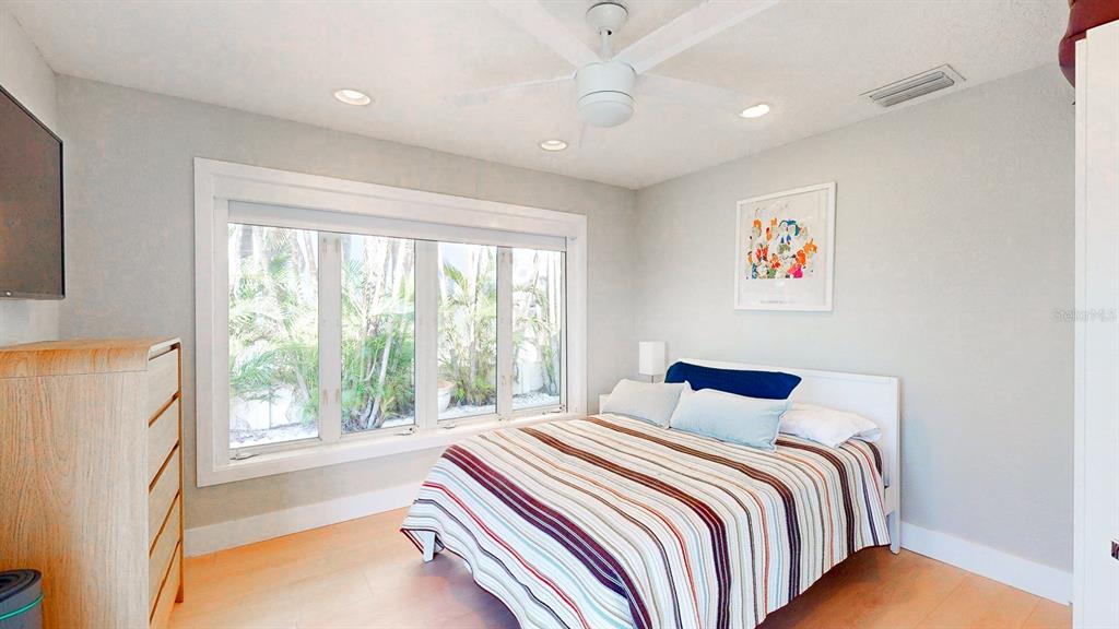 509 55th Avenue St. Pete Beach, FL 33706 - Photo 49 of 63 a bedroom with a bed and a large window