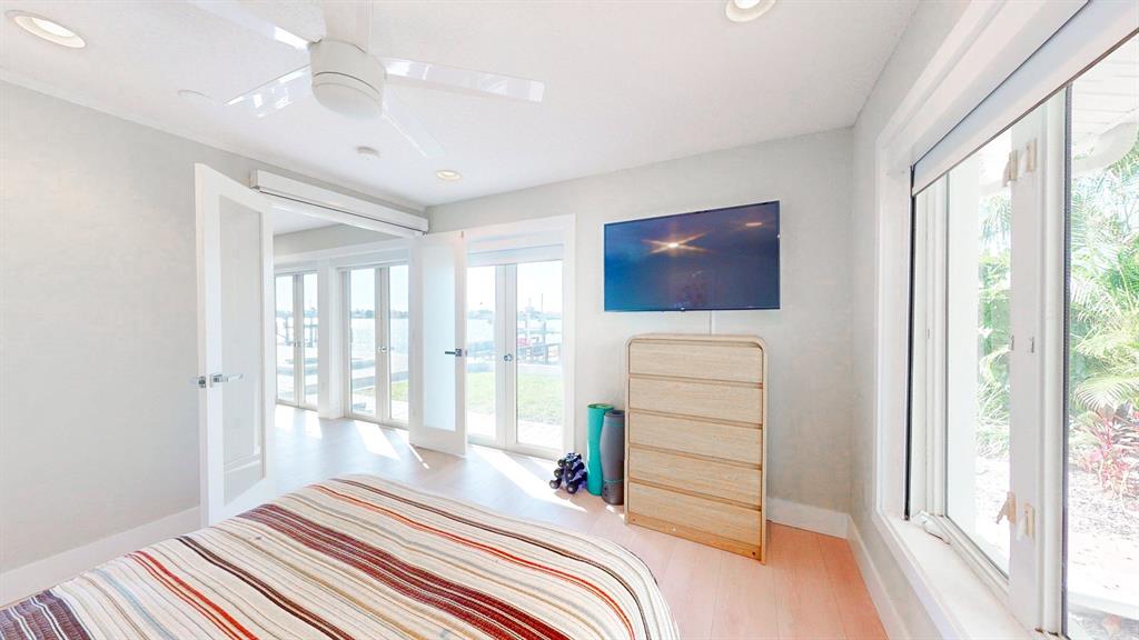 509 55th Avenue St. Pete Beach, FL 33706 - Photo 50 of 63 a bedroom with a bed and a flat tv screen