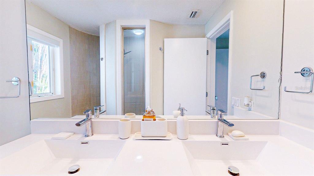 509 55th Avenue St. Pete Beach, FL 33706 - Photo 58 of 63 a bathroom with a double vanity sink with a mirror