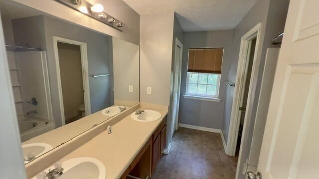 67 Appling Road Eufaula, AL 36027 - Photo 15 of 20 Dual vanity with integrated sinks, expansive wall-mounted mirror, wood-finish flooring, and a window with blinds