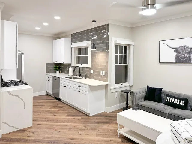 a large white bed in a bedroom next to a window