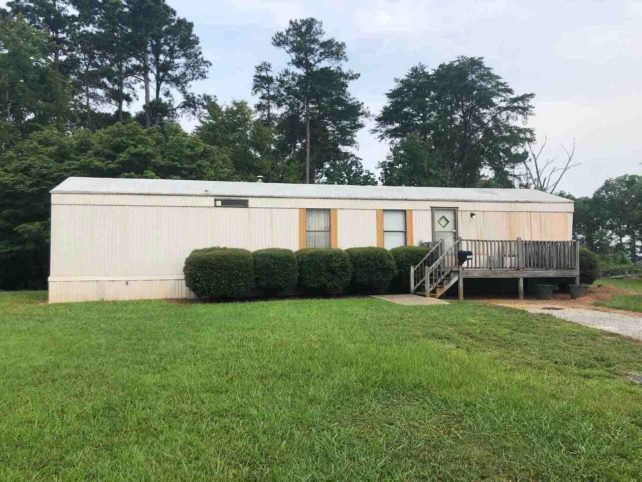 a view of a house with backyard and a tree