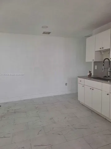 a view of a kitchen with white cabinets