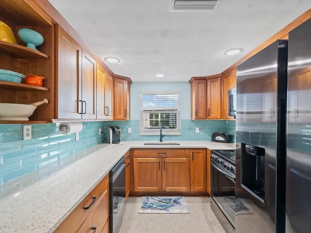 a kitchen with a sink a counter top space cabinets and stainless steel appliances