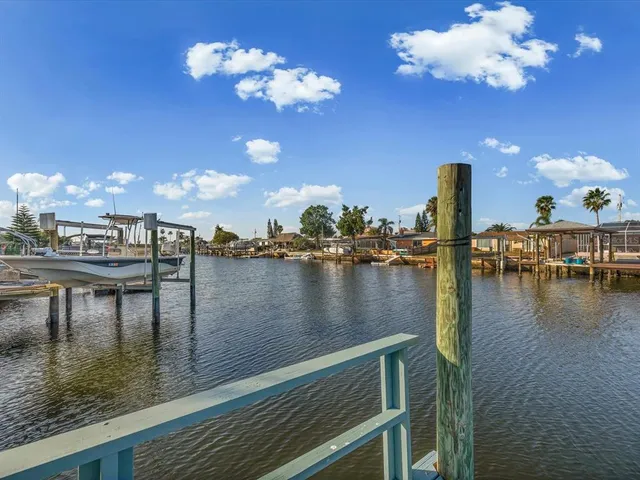 a view of a white house with a yard and table and chairs