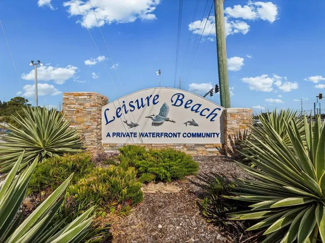 an aerial view of ocean and residential houses with outdoor space