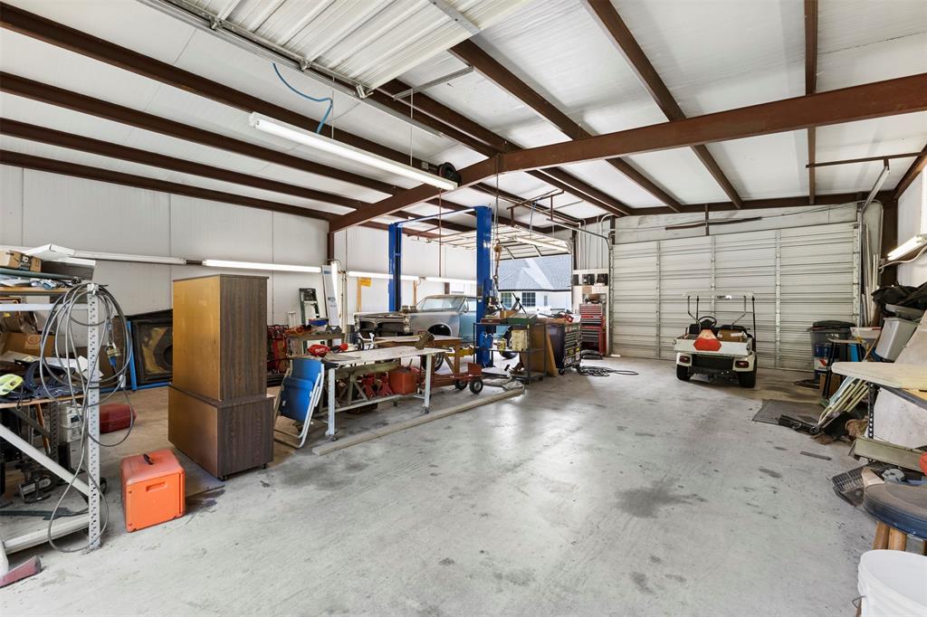 401 Rugged Drive Red Oak, TX 75154 - Photo 36 of 40 34x40 Spacious metal-frame building featuring a concrete floor, high ceilings with exposed beams, and multiple roll-up doors